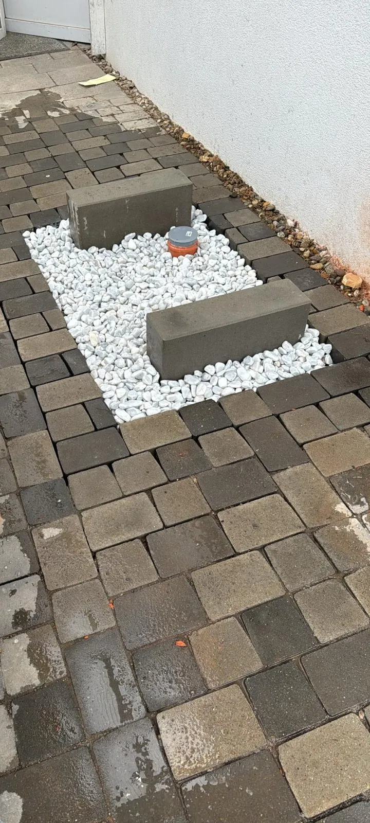 Vorbereitete Aufstellfläche mit Kiesbett, zwei Betonsockeln und Kondensatrohr