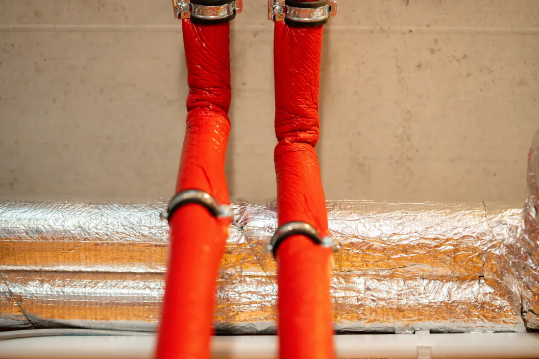 Rot gedämmte Leitungen entlang der Wand