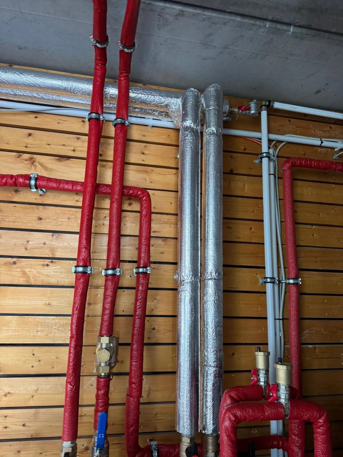 Gedämmte Leitungen einer Bosch-Wärmepumpe an einer Holzwand in Limburgerhof