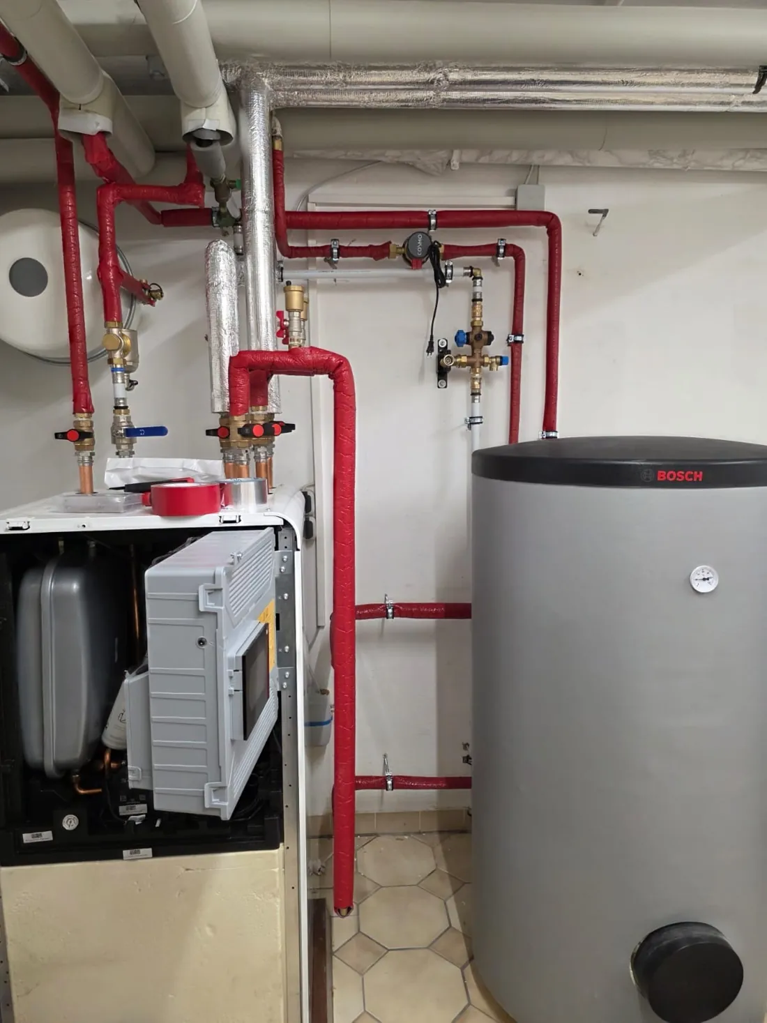 Bosch-Inneneinheit und Warmwasserspeicher im Kellerheizraum in Limburgerhof