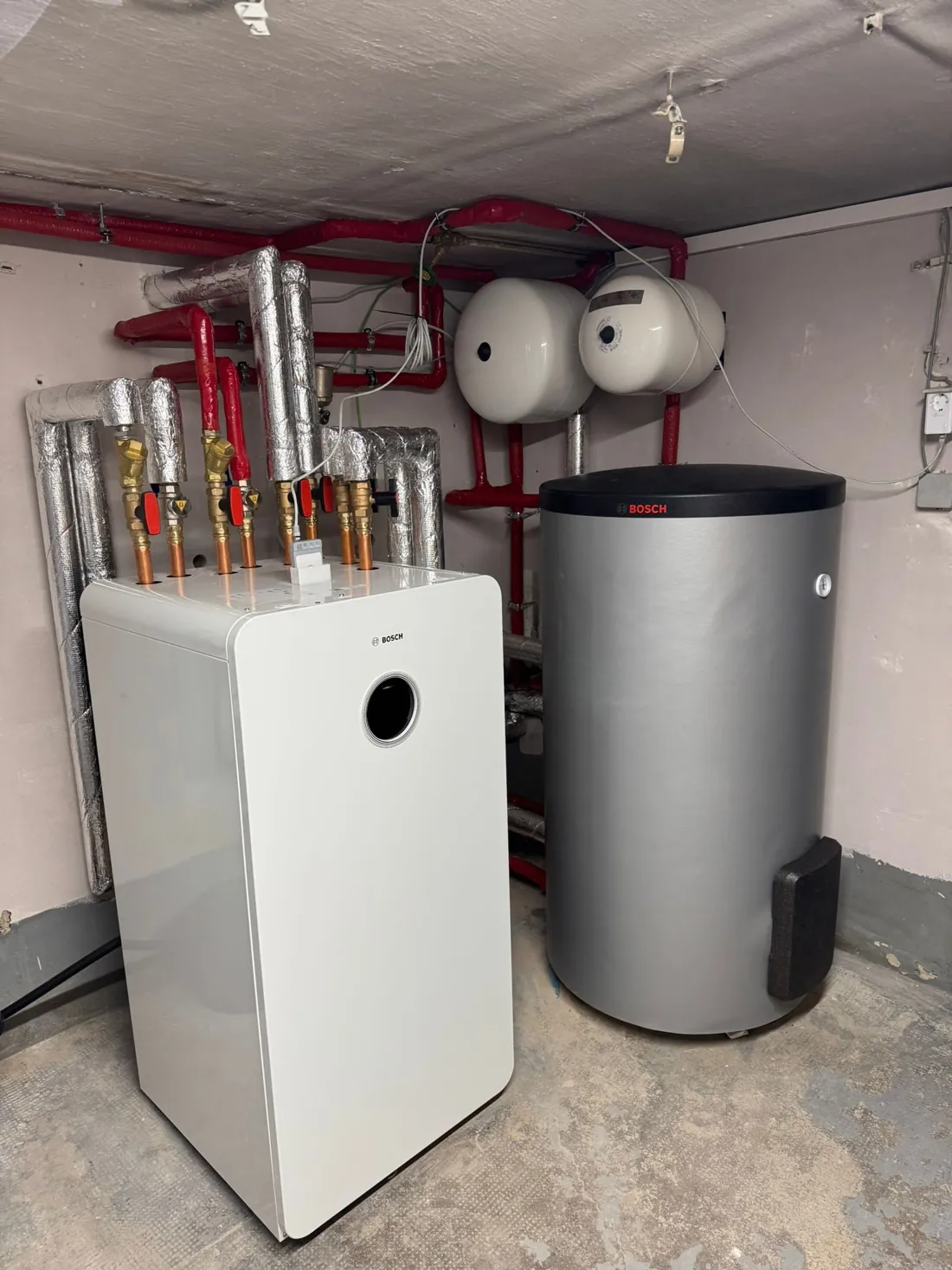 Bosch-Inneneinheit mit Warmwasserspeicher und zwei Ausdehnungsgefäßen im Heizraum