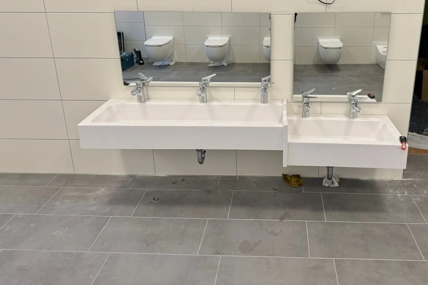 Zwei Rinnenwaschtische in unterschiedlicher Höhe mit Spiegeln in einer Kita in Haßloch