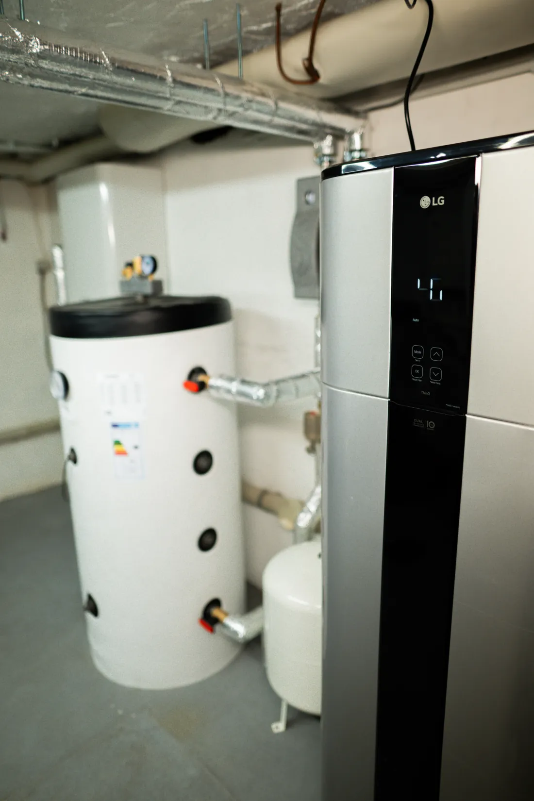 Warmwasser-Wärmepumpe von LG neben dem Pufferspeicher, Blick von vorn