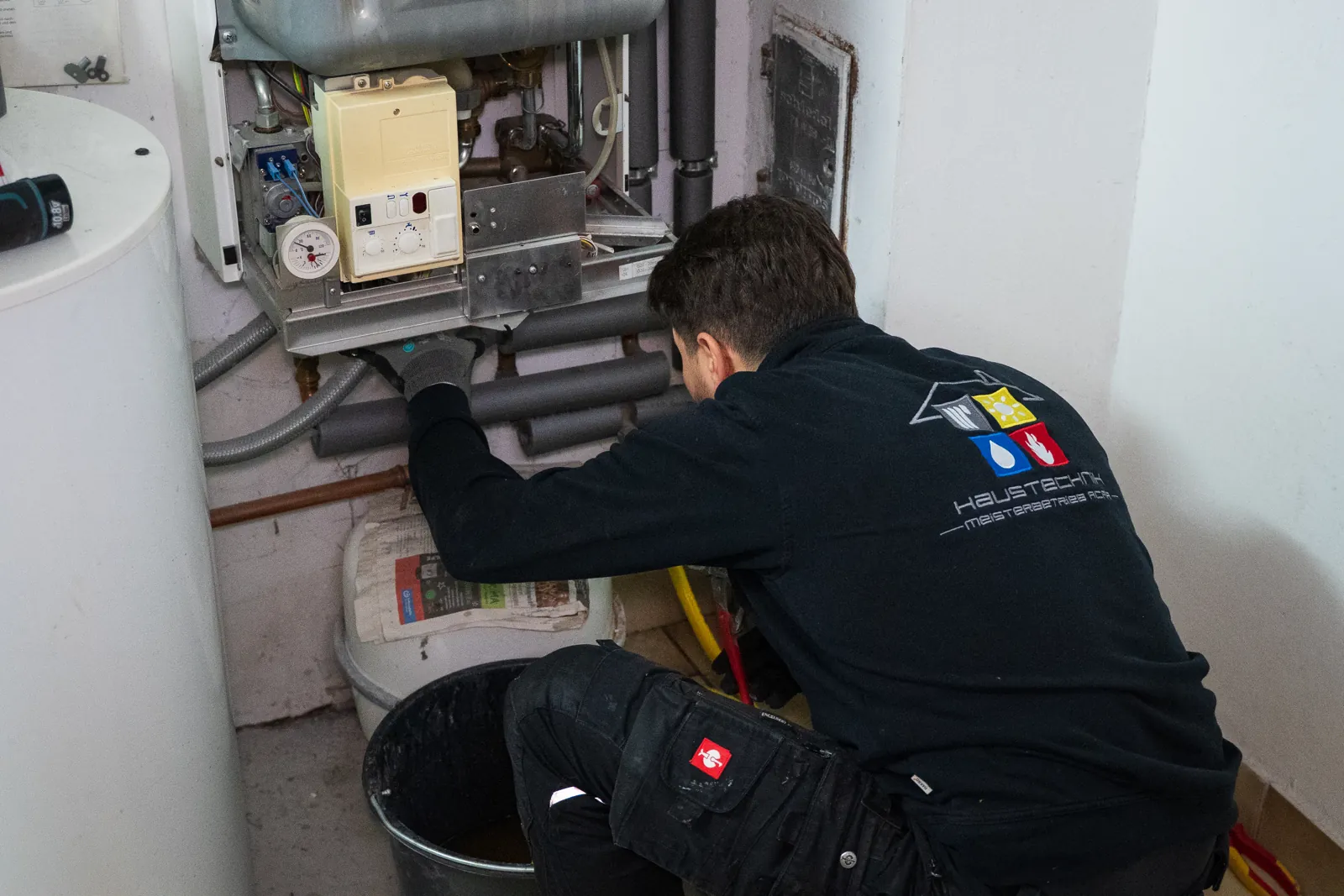 Monteur von Haustechnik Acar bei der Arbeit an einer Heizungsanlage
