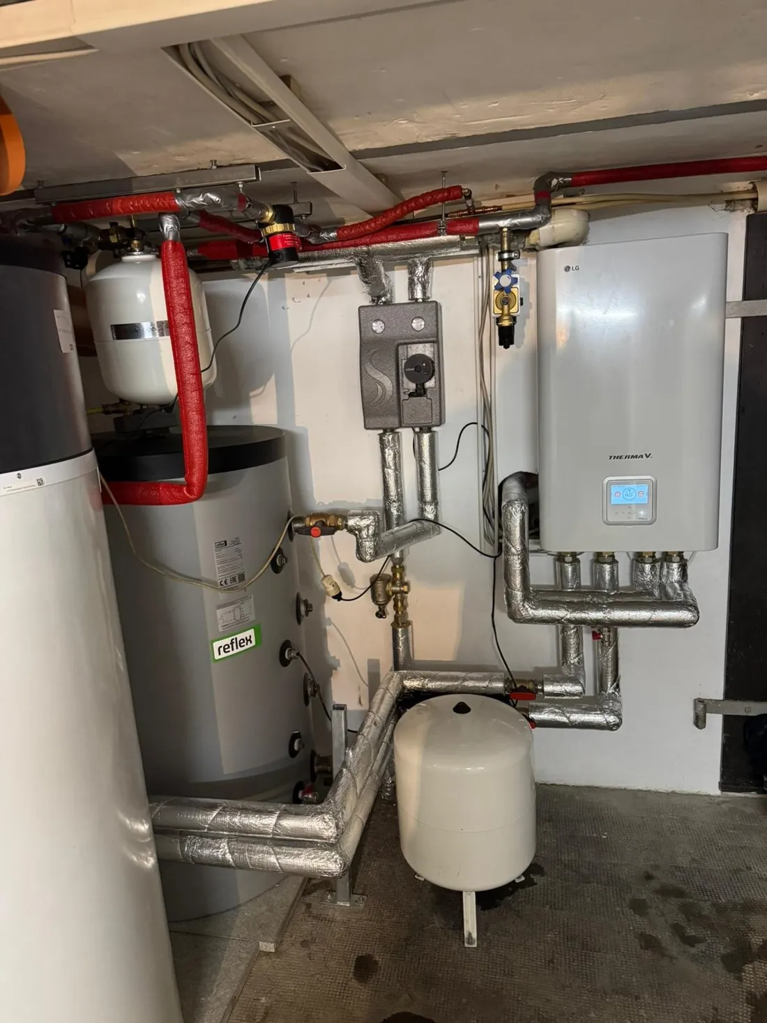 LG-Innengerät einer Heizungs-Wärmepumpe mit Speicher und Ausdehnungsgefäßen, links eine Warmwasser-Wärmepumpe von Vaillant