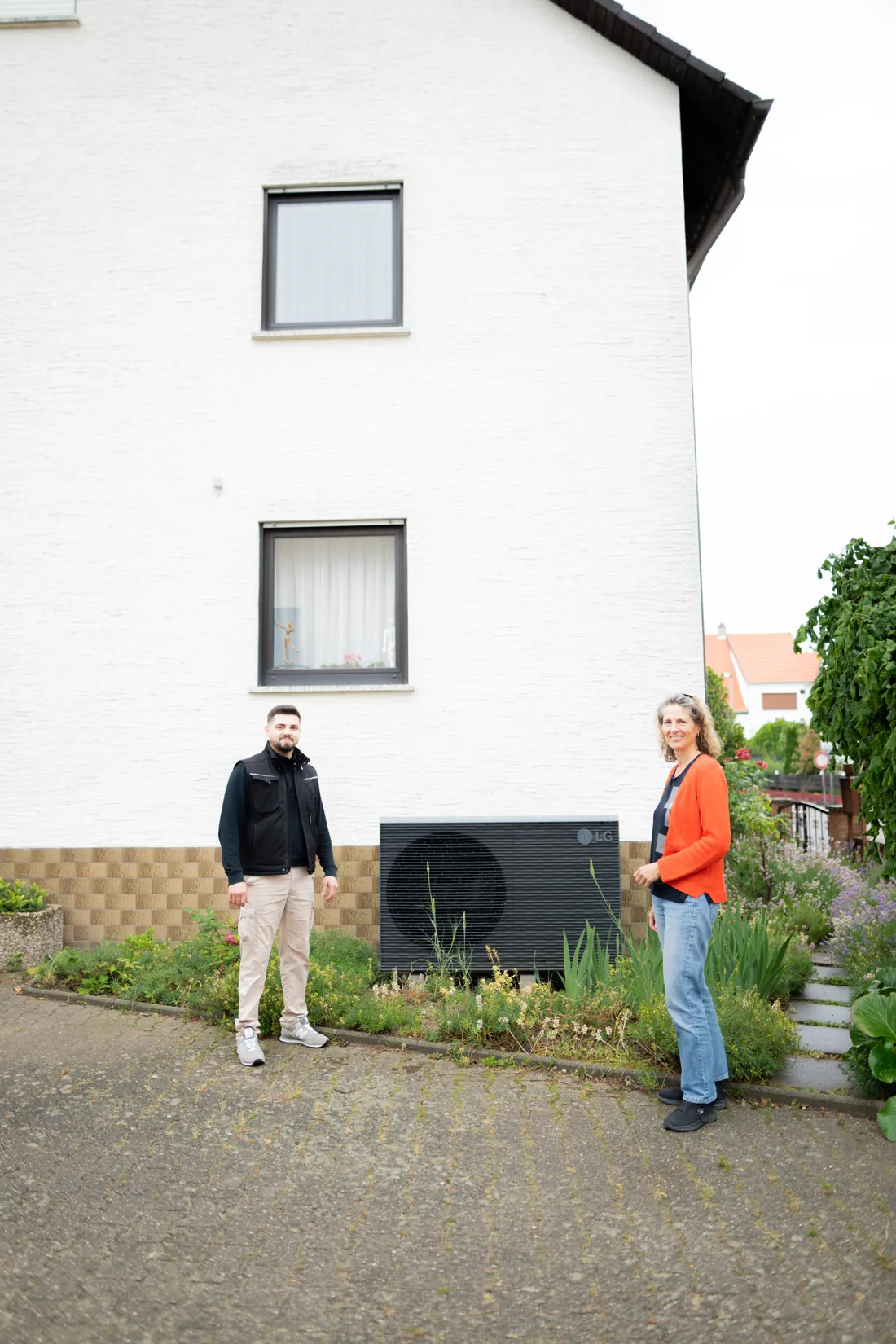 Übergabe der fertigen LG-Wärmepumpe vor dem Wohnhaus